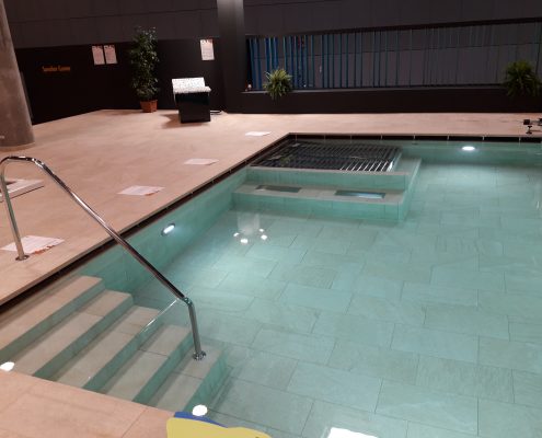 Piscina interior em mosaico verde-água