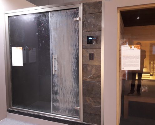 Banho turco com porta de vidro e revestimento em pedra